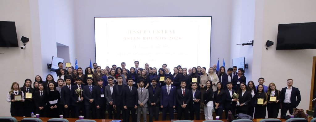 Teams, coaches and judges pose together in the host university hall after the Jessup Central Asian Rounds 2026 awards ceremony.