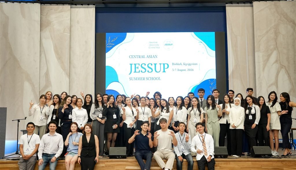 Students and instructors pose together on stage during the Central Asian Summer School.